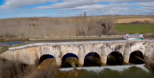 Barco navegando por el canal e Castilla en el acueducto de abánades